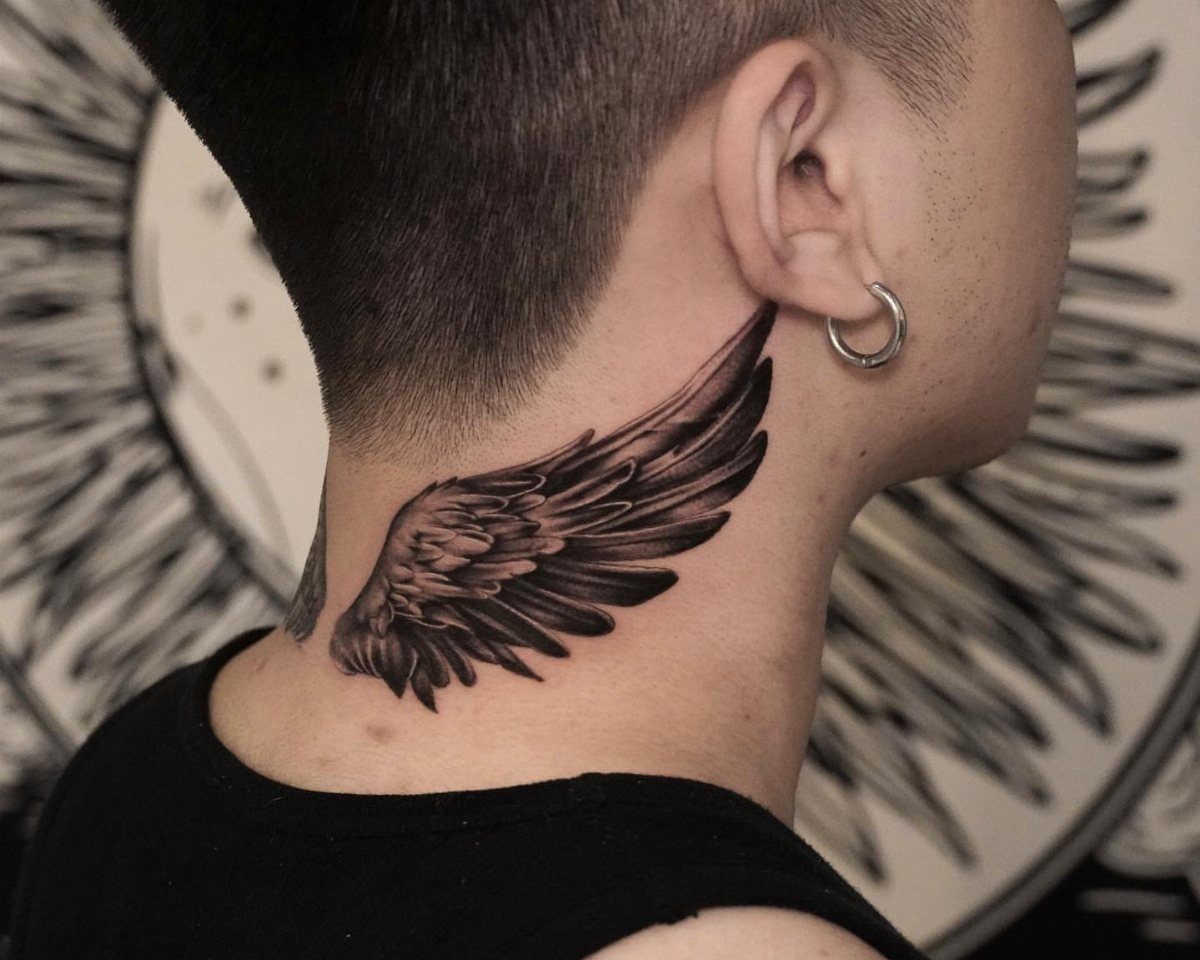 Detailed black and grey feathered wing tattoo on the side of a person's neck.