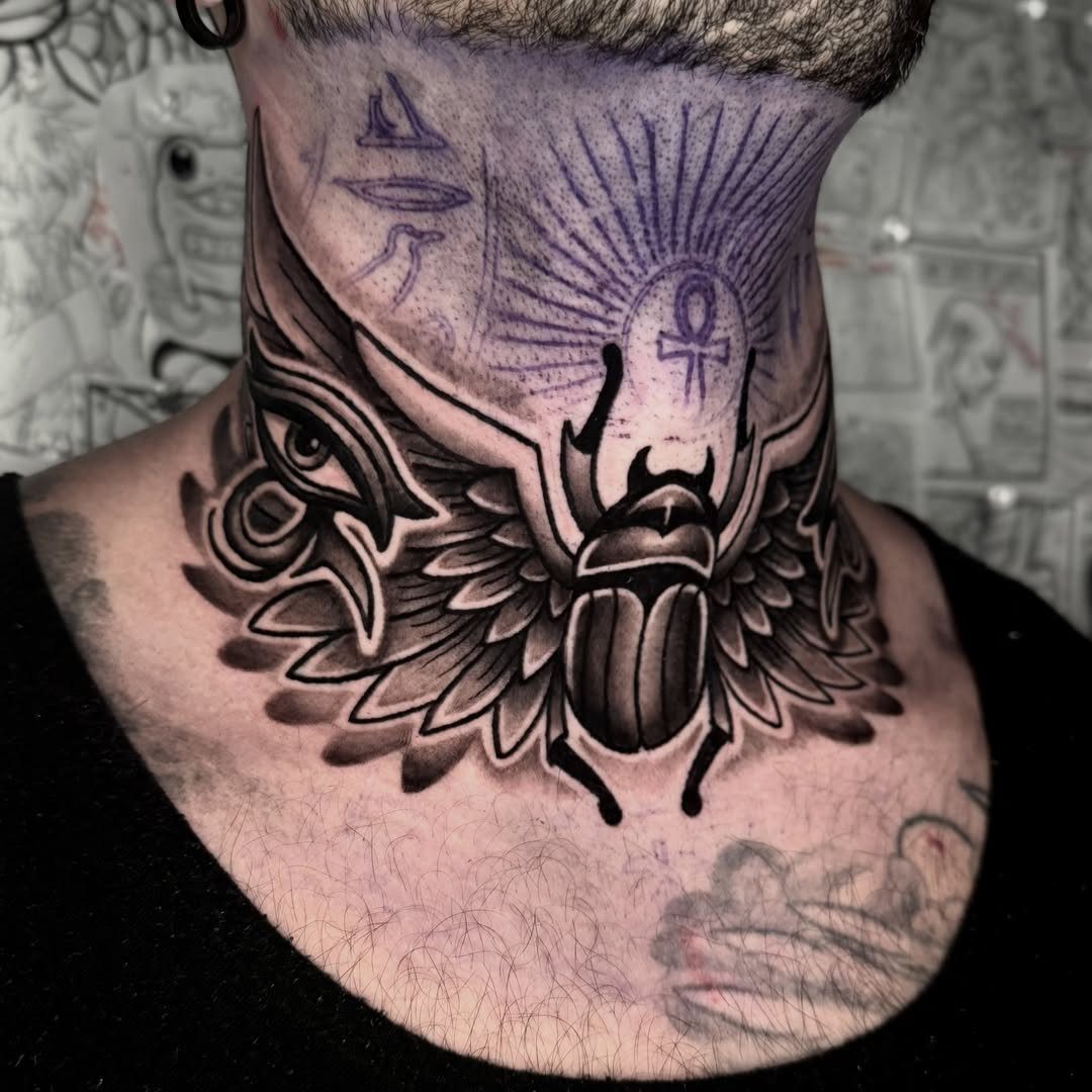 Egyptian scarab beetle tattoo with ankh and Eye of Horus on a neck
