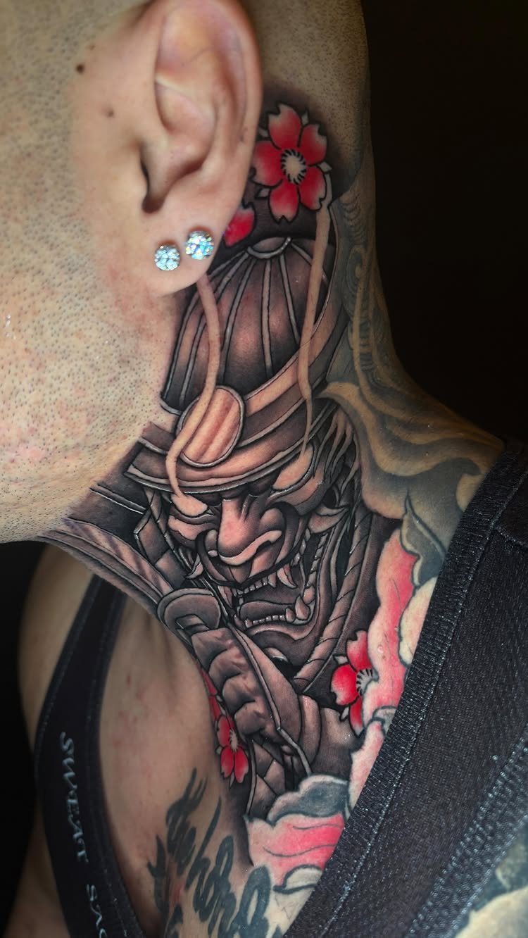 Japanese samurai mask tattoo on a man's side neck with red cherry blossoms.