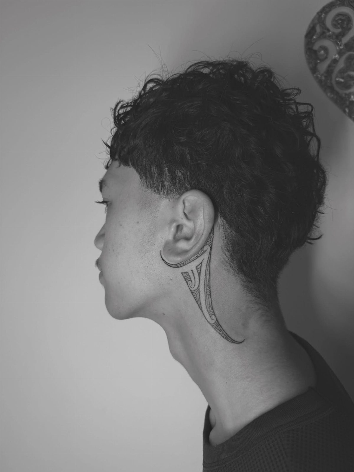 Person with a Kirituhi wave tattoo on the side of their neck.