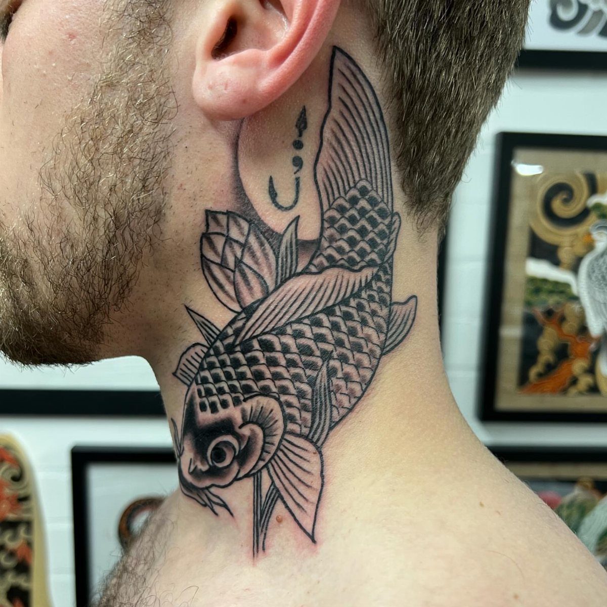 Koi fish tattoo on the side of a man's neck with detailed scales.