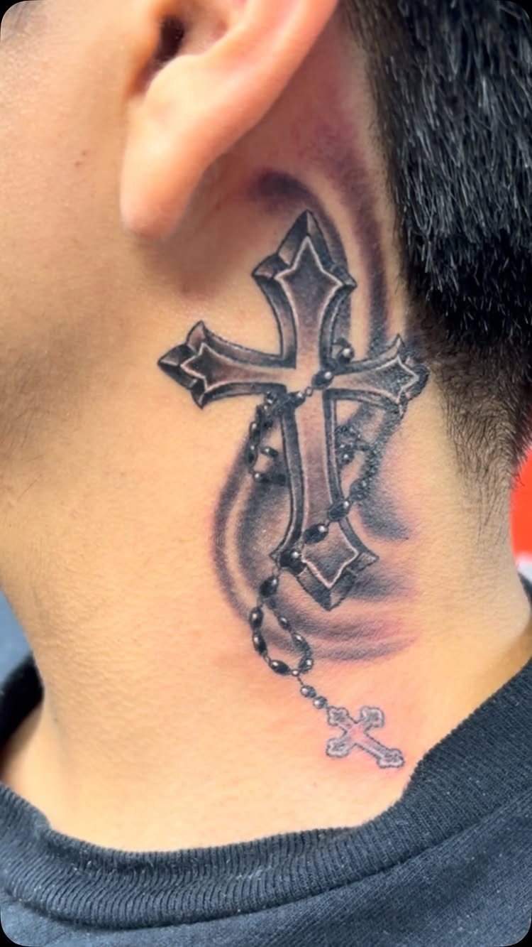 Ornate cross tattoo with a rosary chain on the side of a neck.