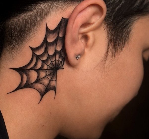 Spider web tattoo in black ink on the side of a person's neck.