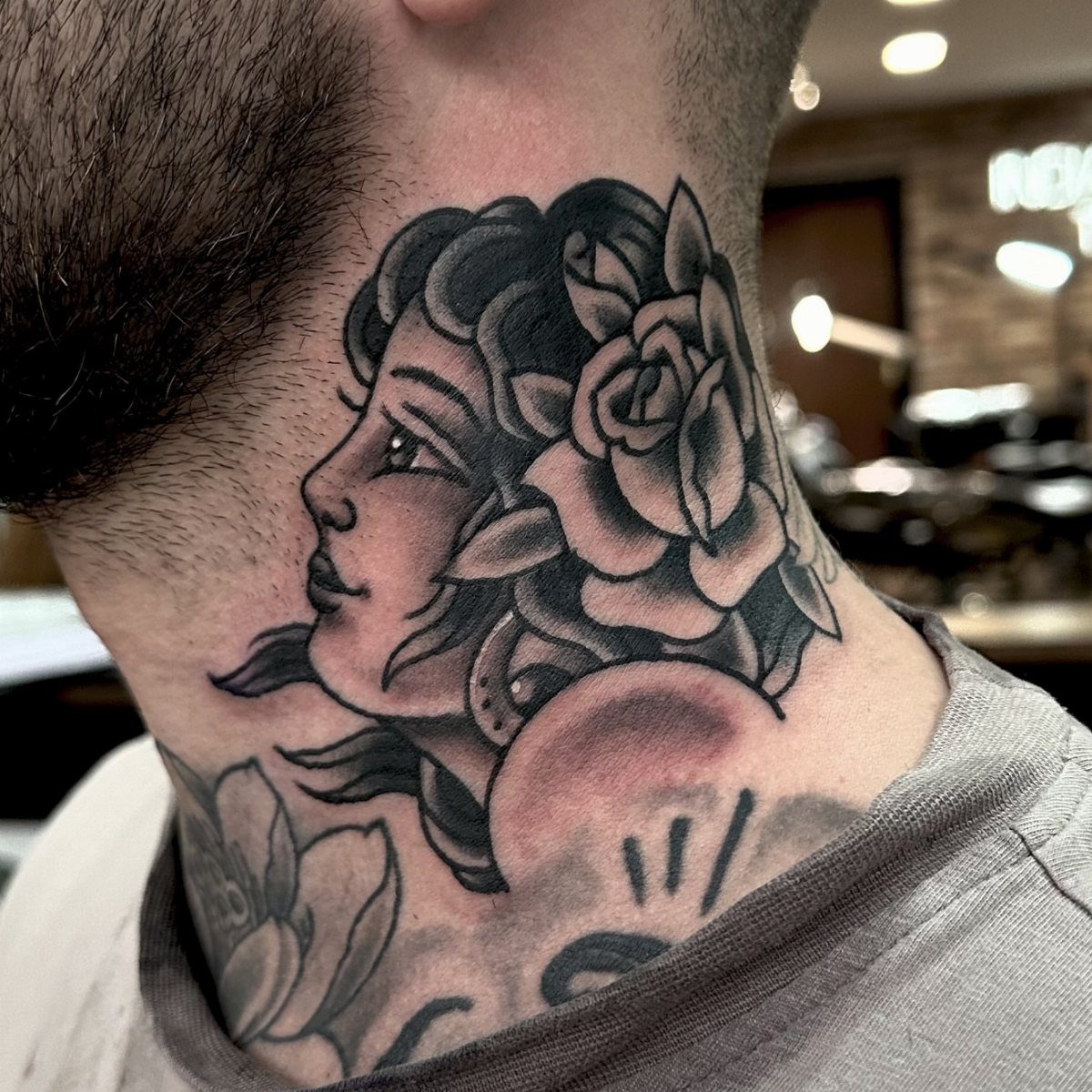 Woman's profile with a rose tattoo on the side of a man's neck