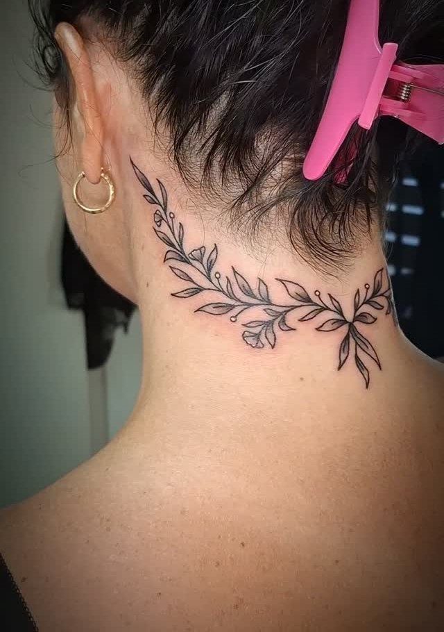 Floral vine tattoo with small leaves on the back of a person's neck