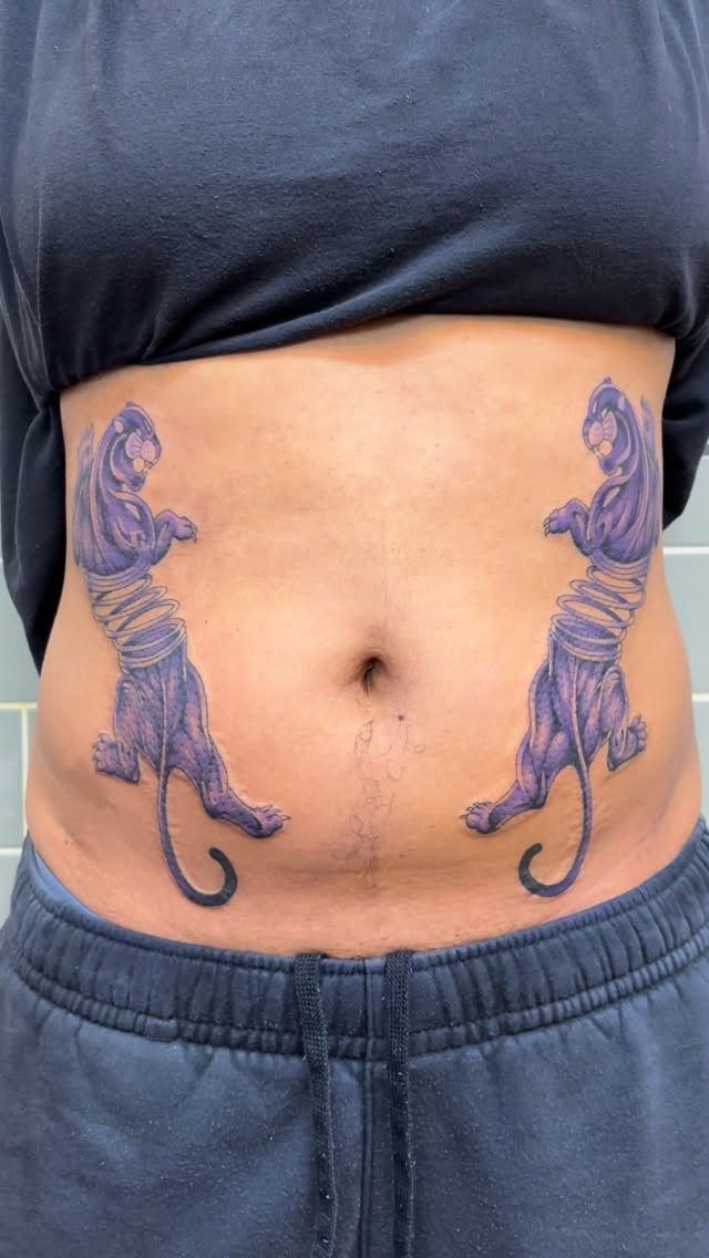 Two purple panther tattoos on a woman's stomach, each panther tied with bands.