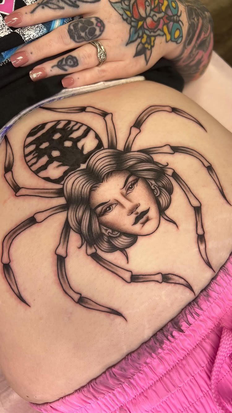 Spider tattoo with a woman's face on a person's stomach in black and gray