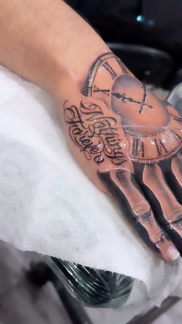 Hand with a 3D tattoo of a clock and script reading Always Forever