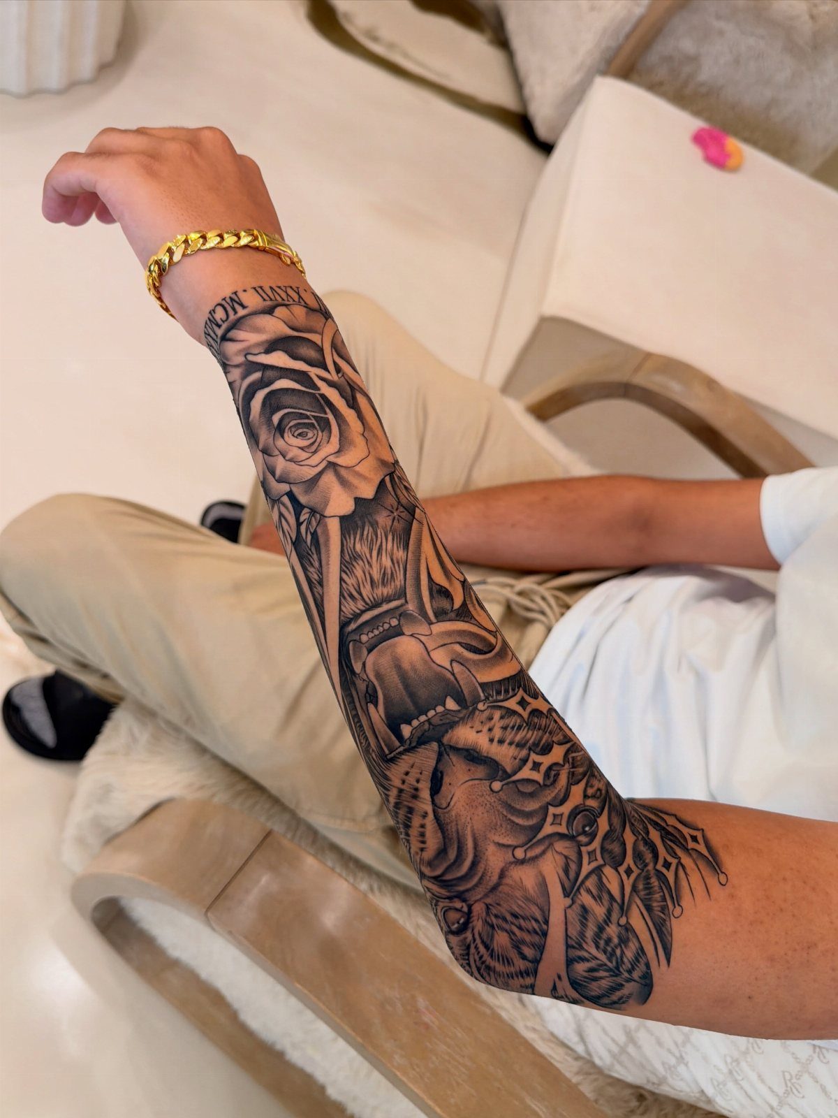Man's forearm with a black ink tattoo featuring a rose and a skull.