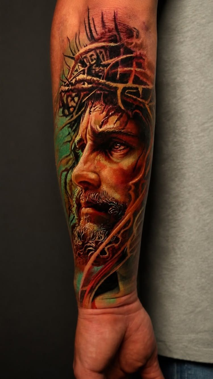 Detailed portrait tattoo of Jesus with a crown of thorns on a man's forearm.