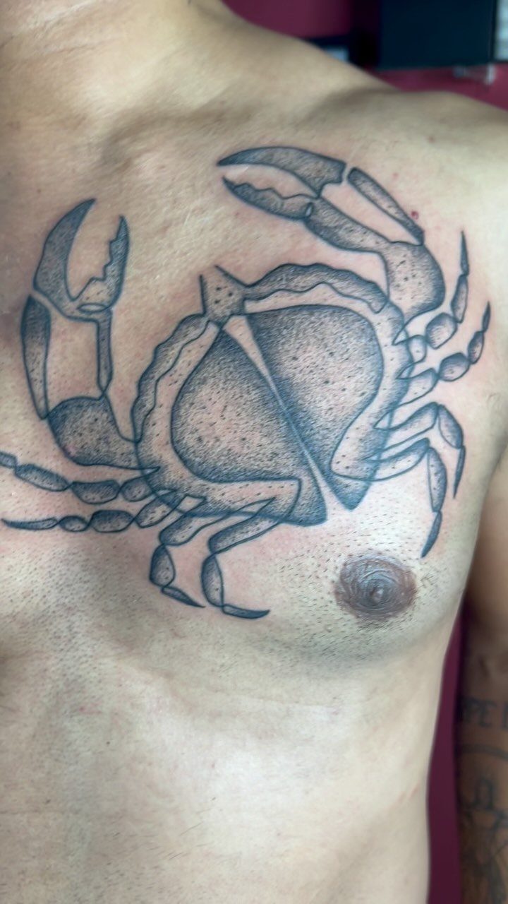 Crab tattoo on a man's chest representing the Cancer zodiac sign.