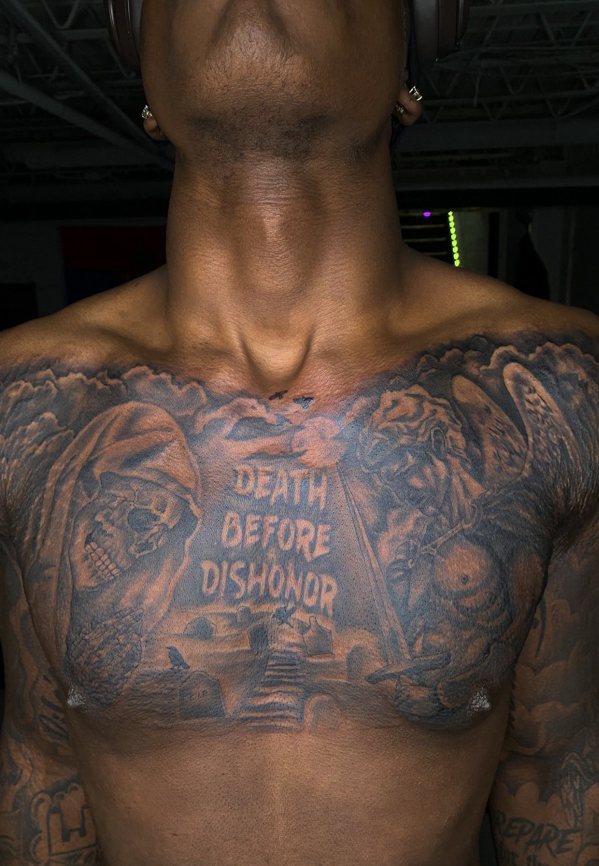 Full chest panel tattoo with skulls and text Death Before Dishonor on a man
