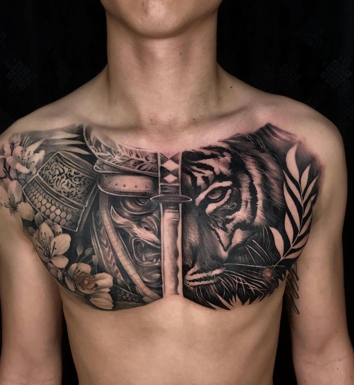Chest tattoo featuring a split design of a samurai mask and a tiger face.