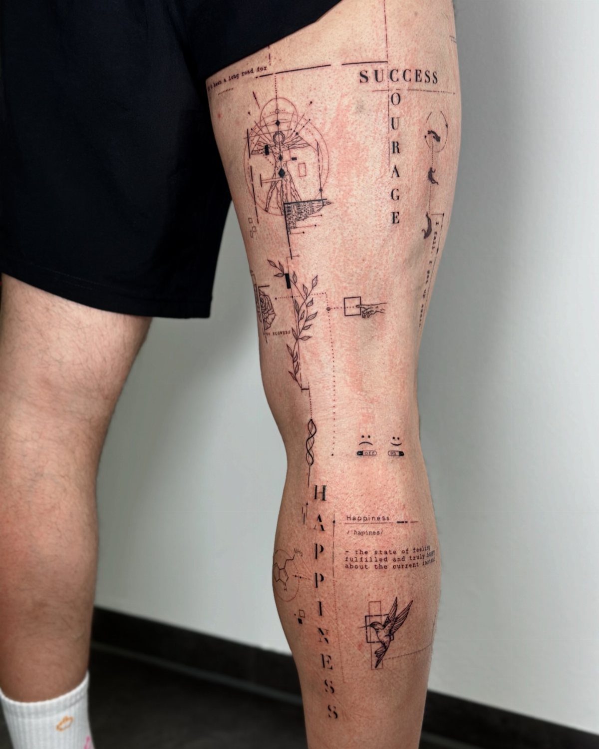 Linework tattoo on a man's leg featuring geometric shapes and minimalist text.