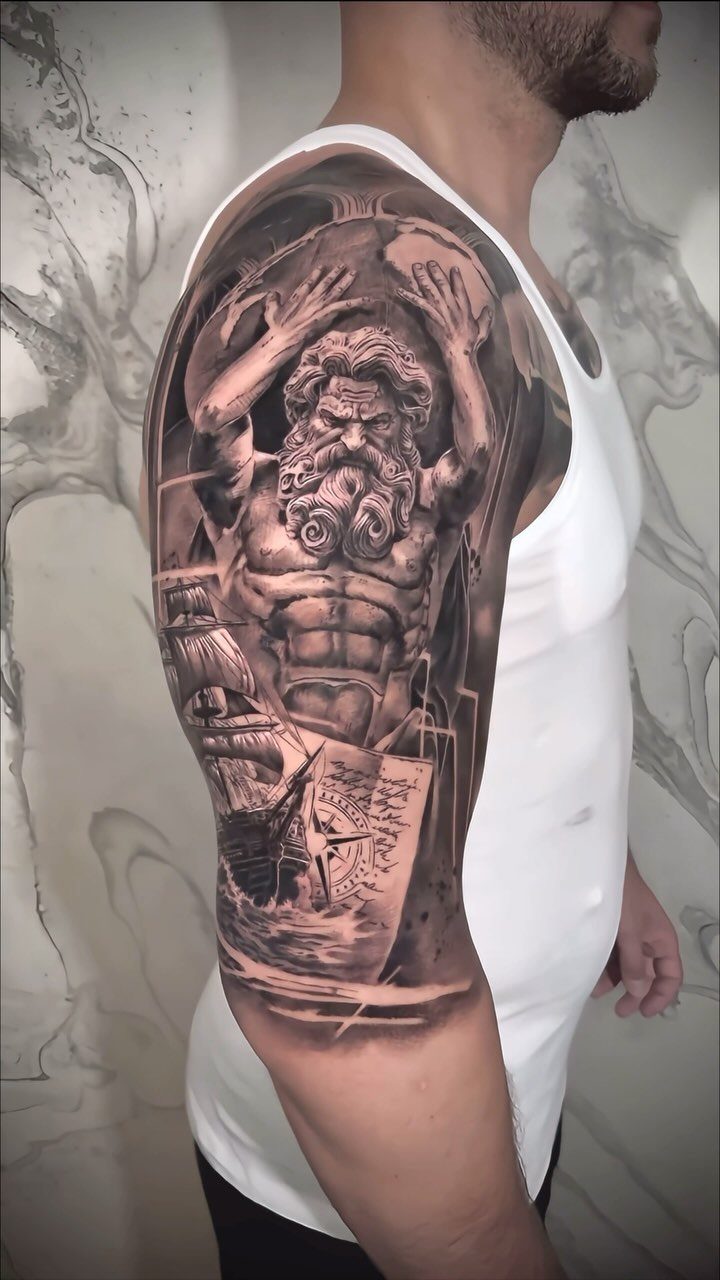 Poseidon and nautical map tattoo on a man's muscular upper arm