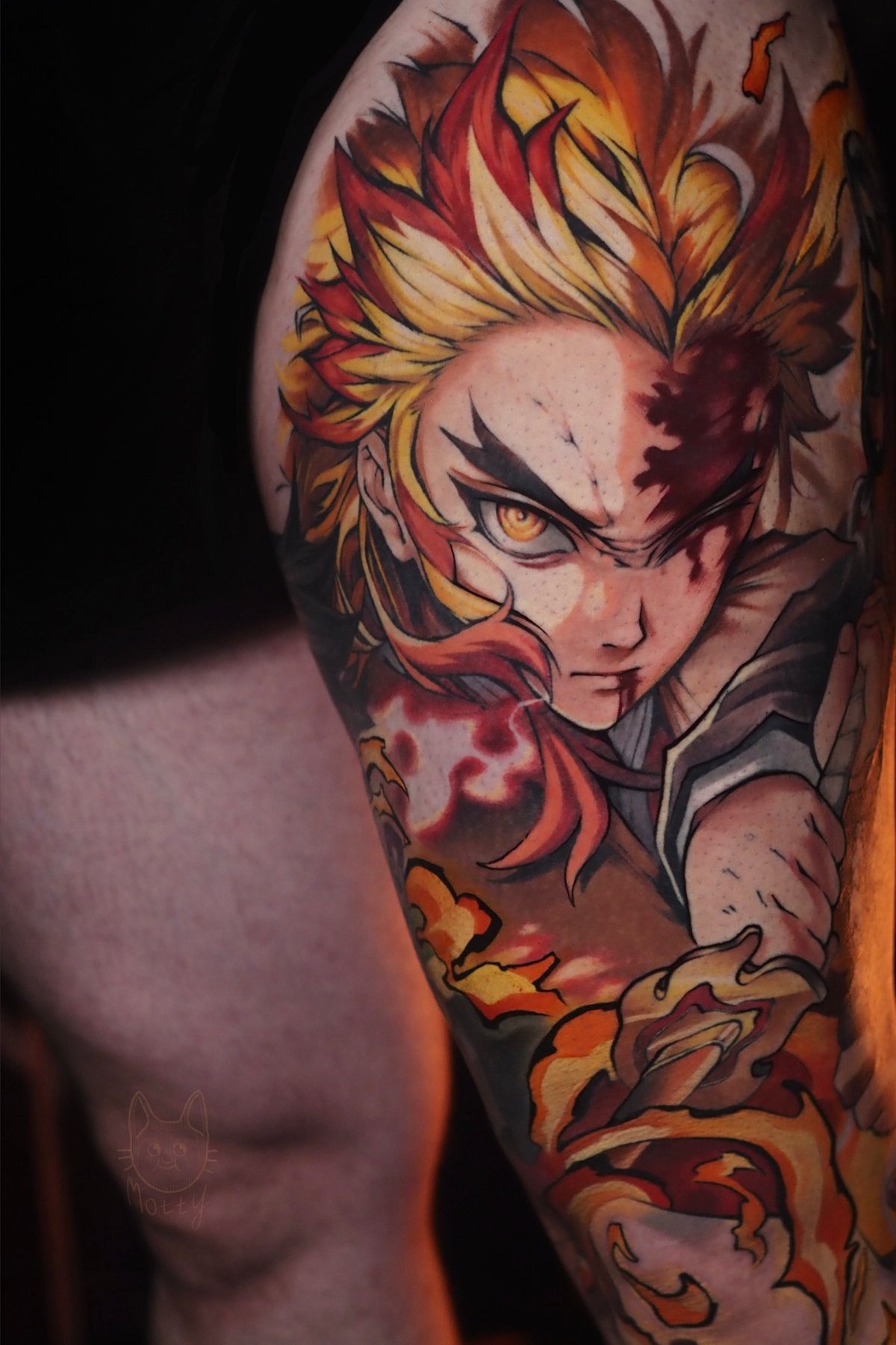 Anime tattoo sleeve on an arm featuring a character with fiery red and yellow hair.