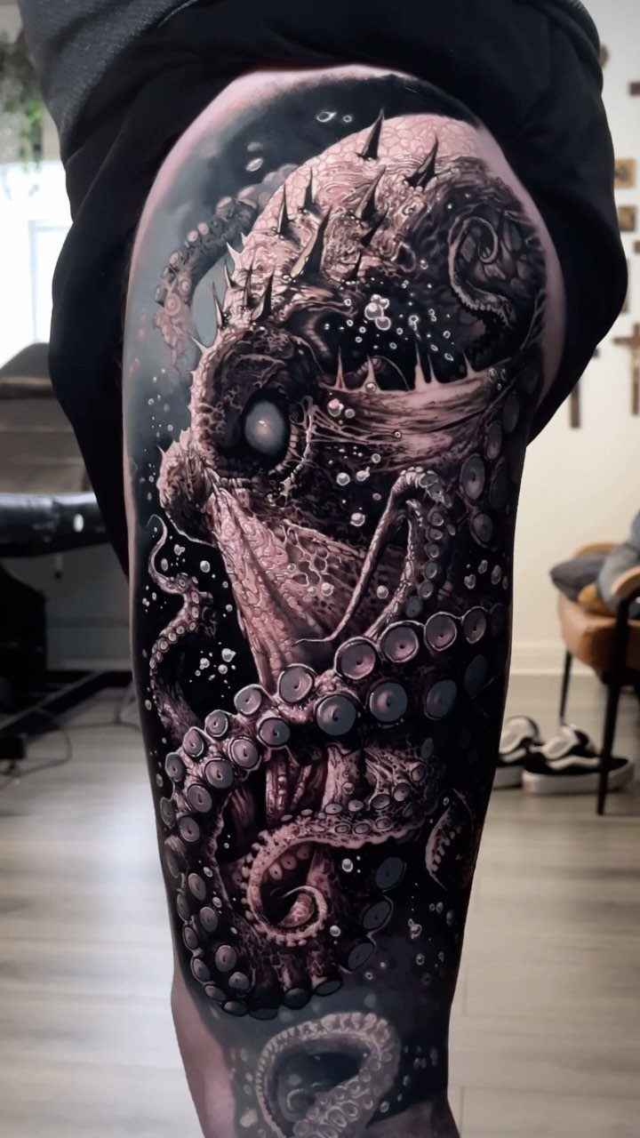 Detailed black and grey octopus tattoo covering a person's thigh with intricate textures.