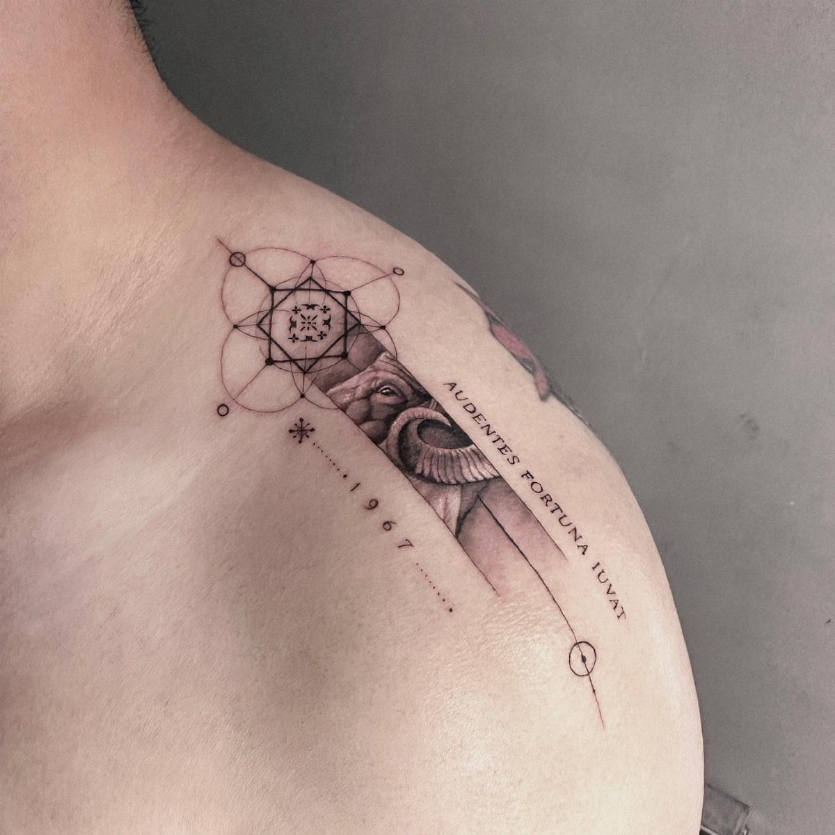 Geometric tattoo with interlocking circles and a ram on a man's shoulder.