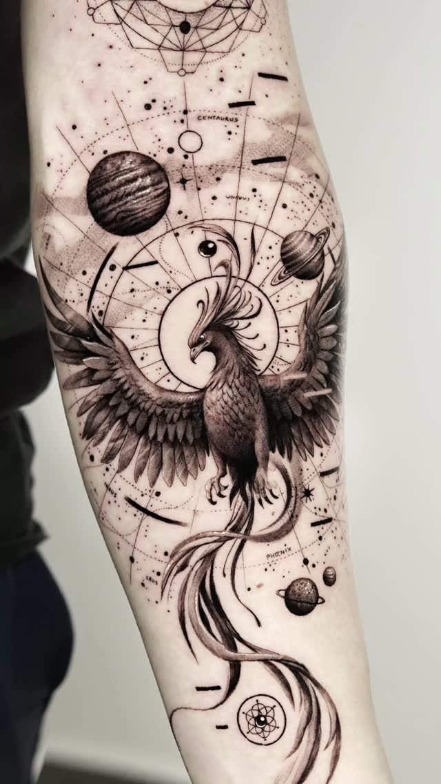 Phoenix tattoo on a man's arm with celestial planets and geometric patterns.