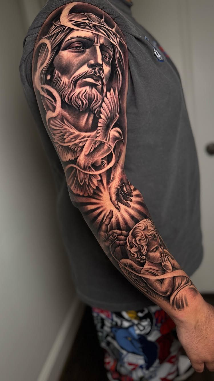 Detailed black and grey tattoo sleeve of Jesus, a dove, and a cherub.