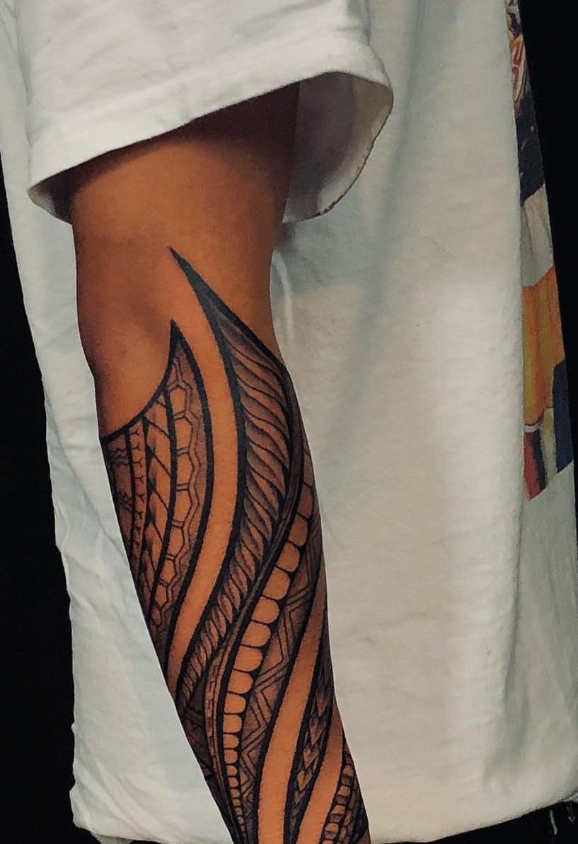 Tribal tattoo with bold black geometric patterns on a man's upper arm.
