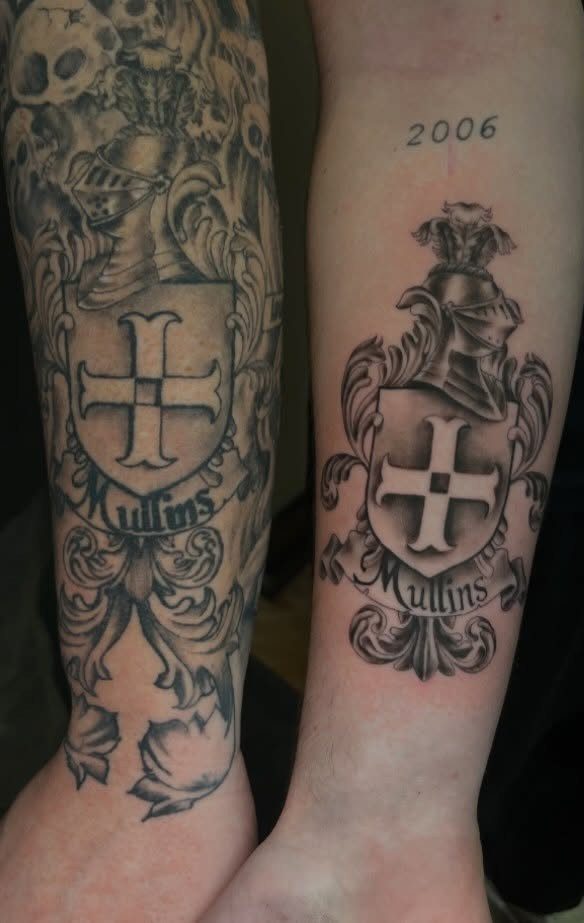 Family crest tattoos on two forearms featuring a shield, helmet, and the name Mullins.