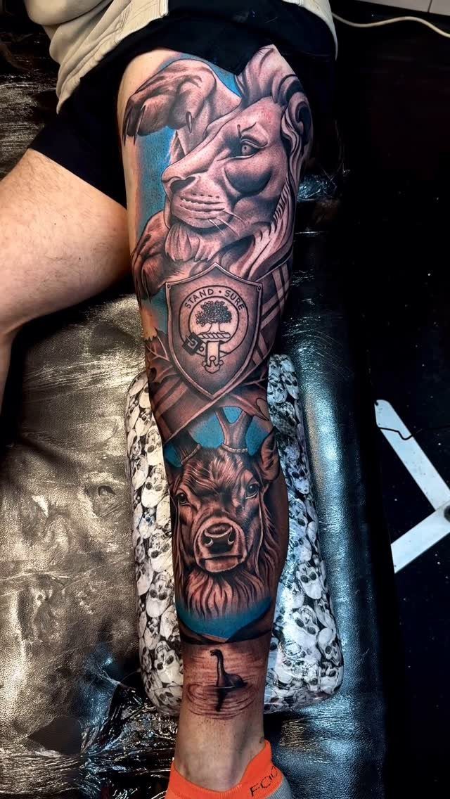 Leg sleeve tattoo featuring a lion, a shield, a deer, and a flamingo.