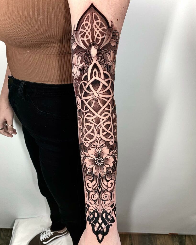 Celtic knot half sleeve tattoo with floral details on a person's arm.