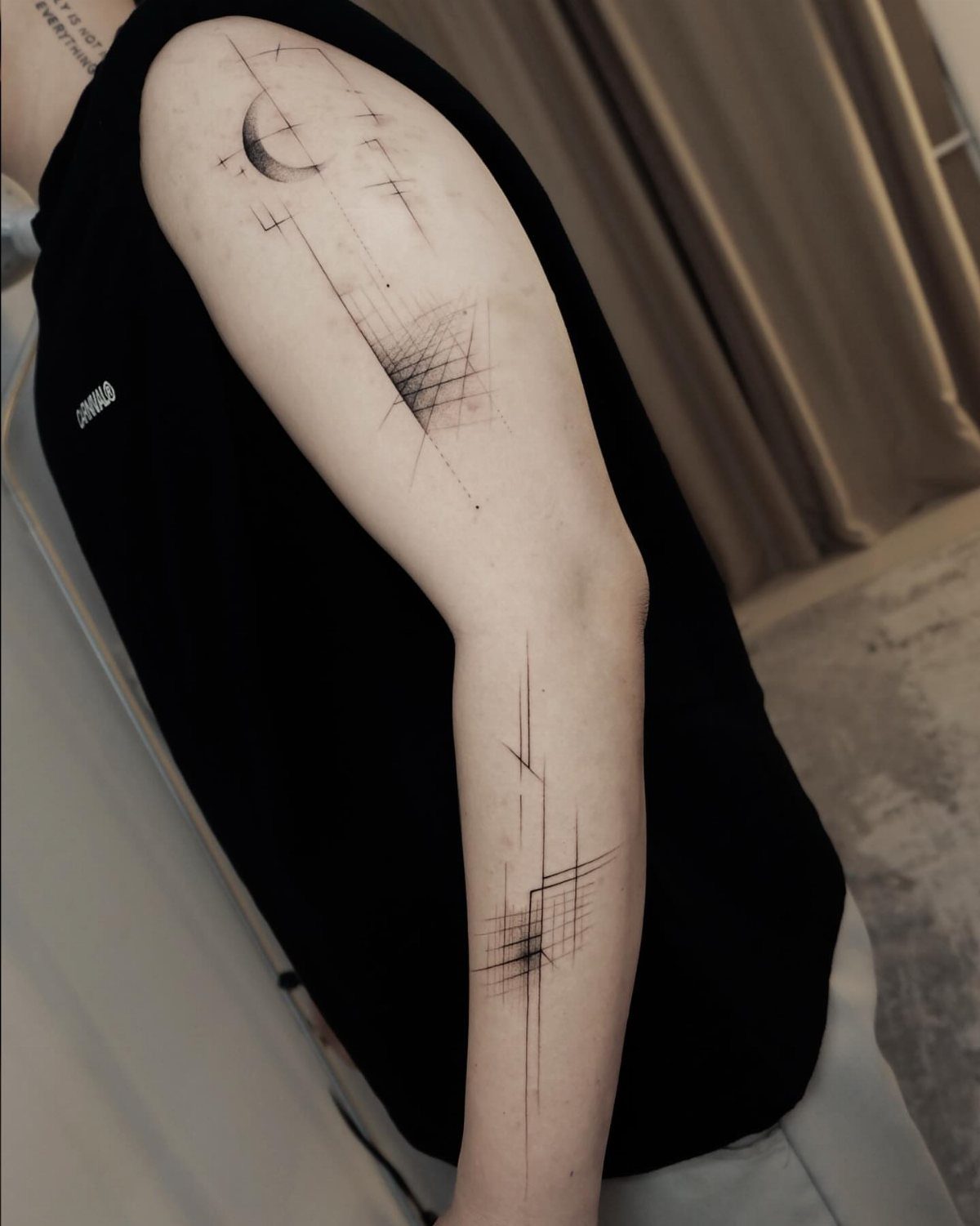 Geometric half sleeve tattoo with thin black lines and a crescent moon.