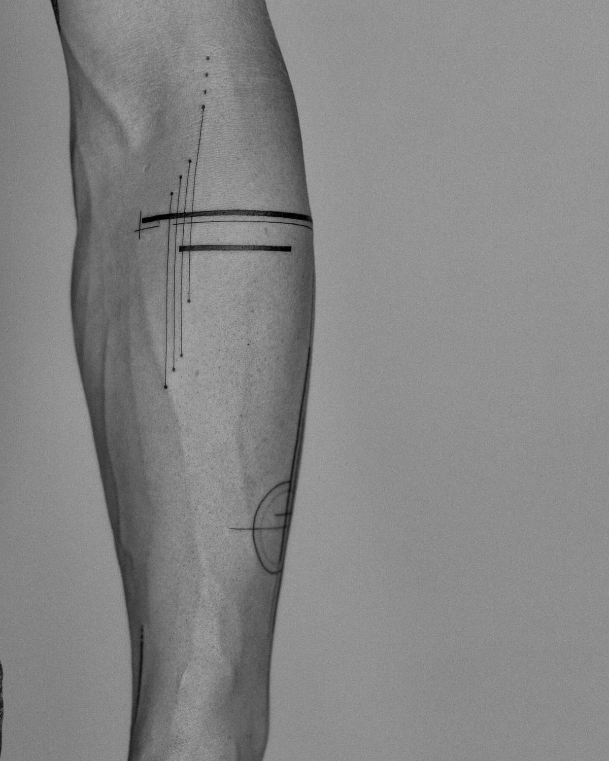 Minimalist tattoo with thin black lines and dots on a person's arm