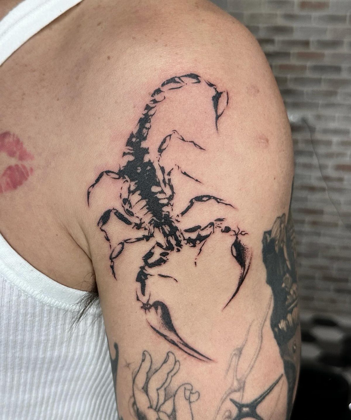 Scorpion tattoo with detailed pincers and tail on a person's upper arm.