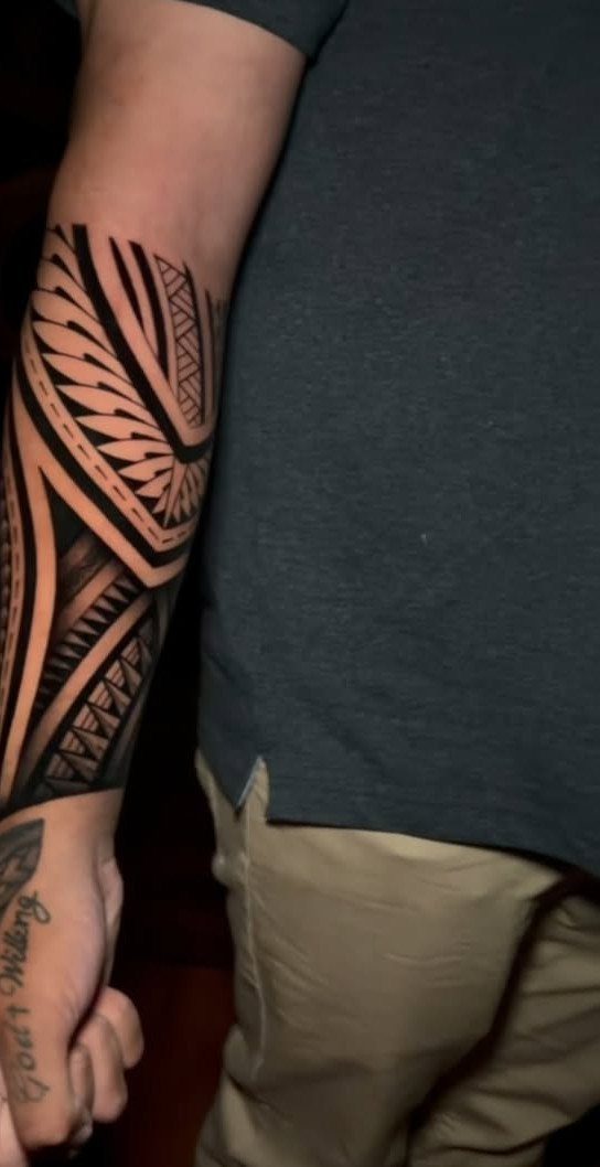 Tribal tattoo with bold black geometric patterns on a man's forearm