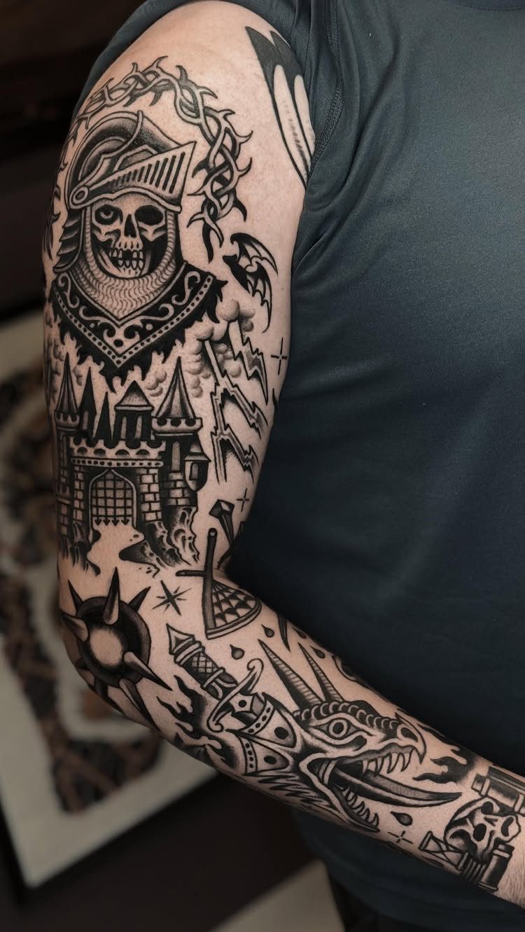 Black ink patchwork tattoo sleeve on an arm featuring a skeleton knight and castle.