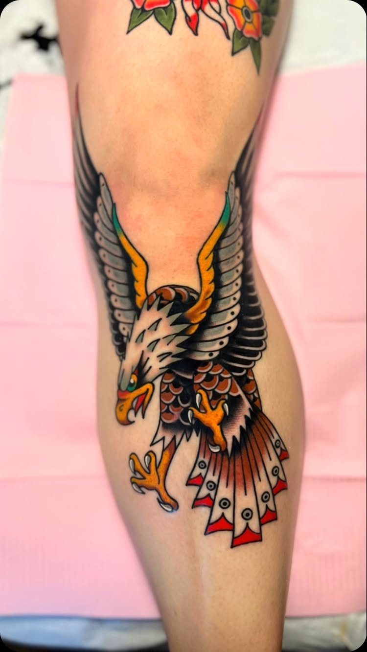 Traditional bald eagle tattoo with bold outlines on a person's lower leg.