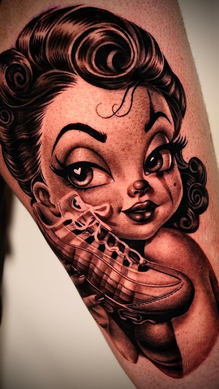 Pin-up girl tattoo with curly hair holding a roller skate on skin.
