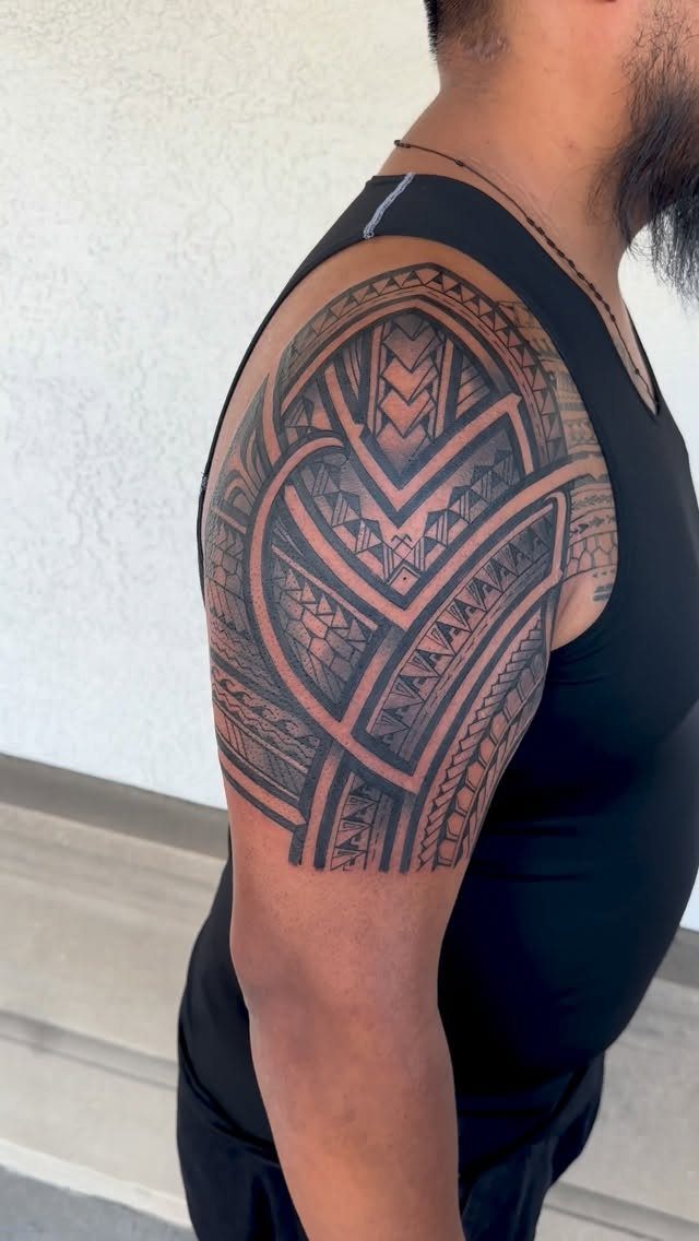 Tribal tattoo with bold geometric patterns on a person's upper arm