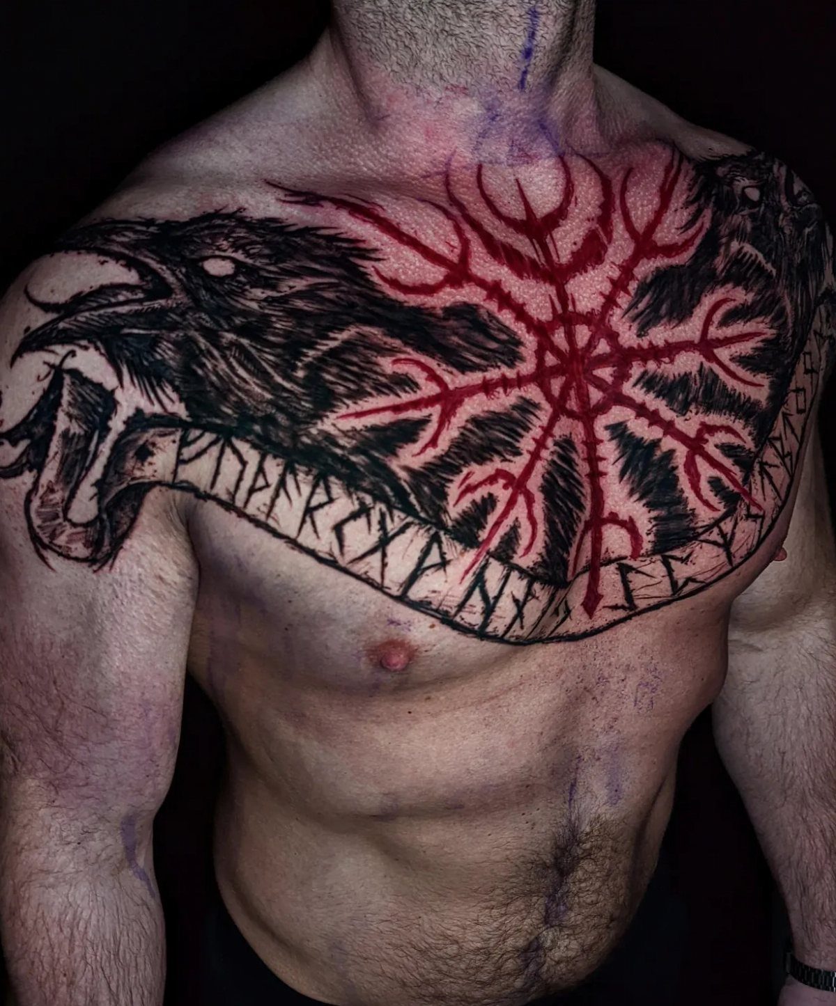 Chest tattoo featuring a red Aegishjalmur symbol and a black raven with runes.