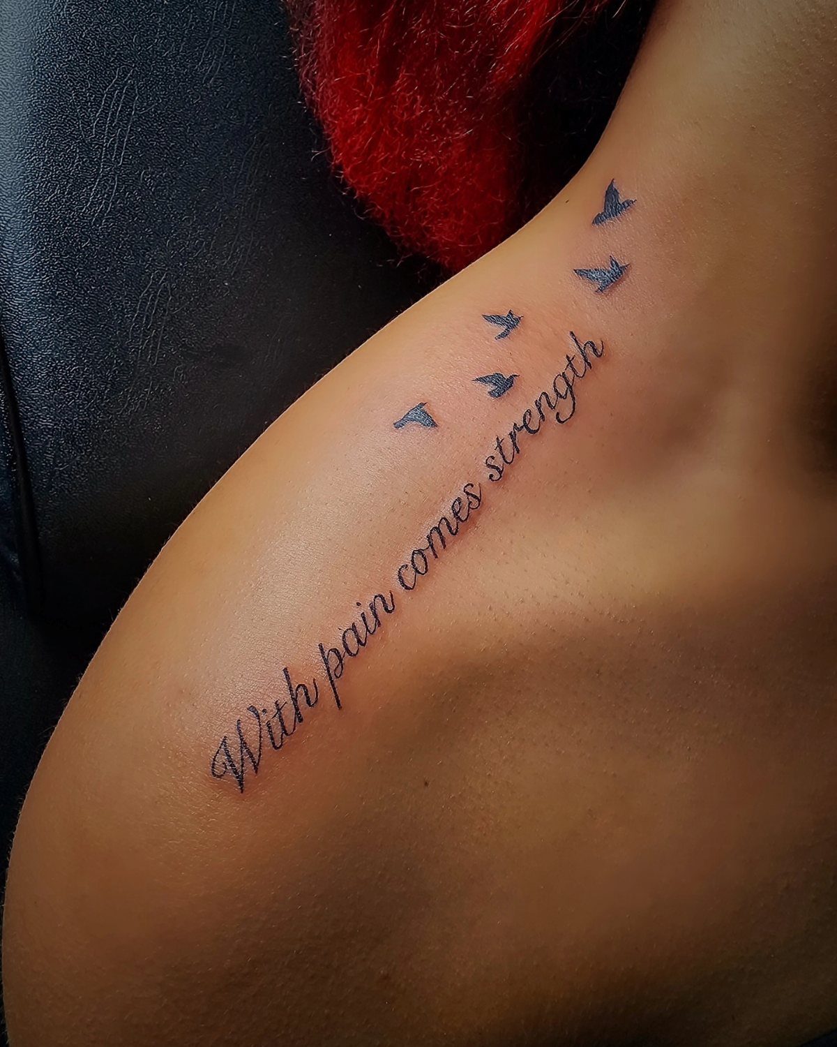 Cursive quote tattoo with flying birds on a person's side ribcage area.
