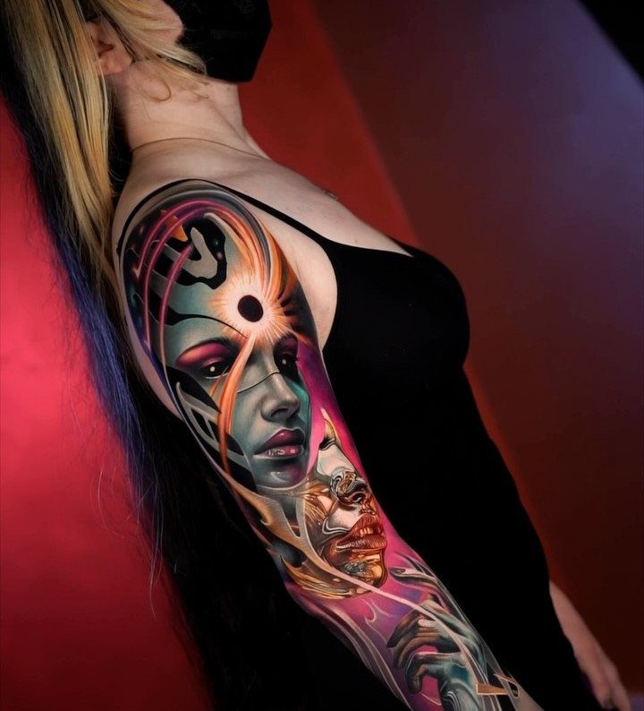 Woman with a colorful full sleeve tattoo featuring a stylized female face.