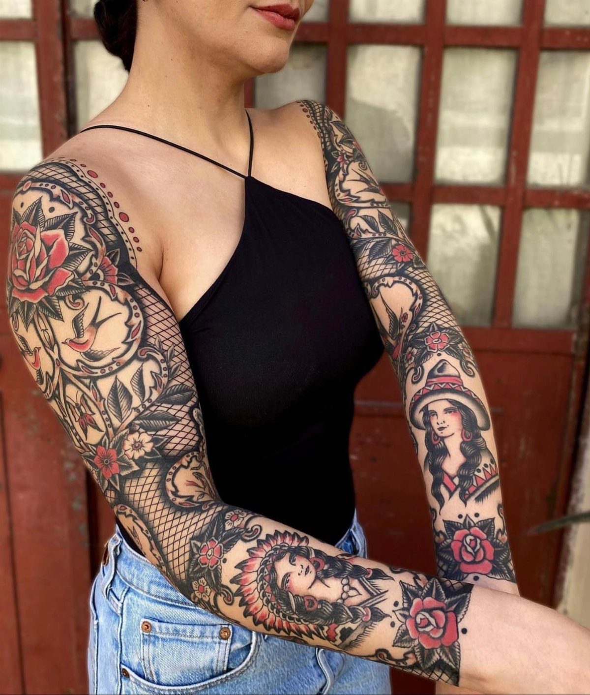 Woman with full sleeve tattoos featuring red roses and traditional female portraits.