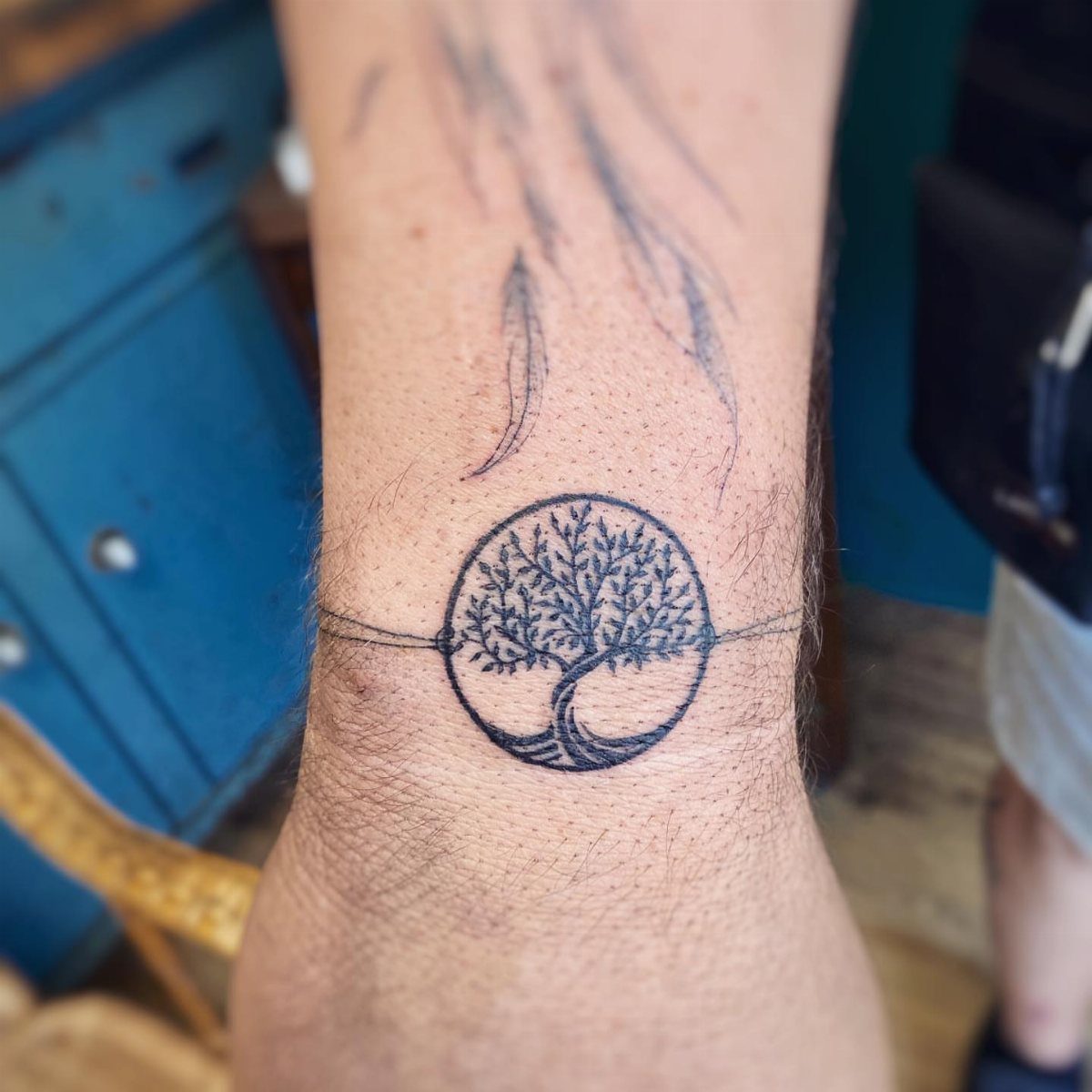 Tree of life tattoo in a circle on a man's hairy wrist